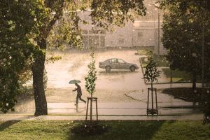 man with umbrella walking in rain storm