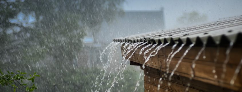 Rain flows down from a roof down