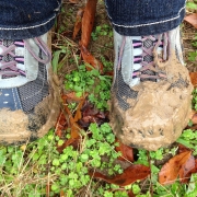 person standing in muddy grassed area