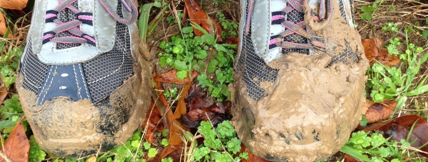 person standing in muddy grassed area