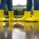 two people facing one another wearing yellow rain boots