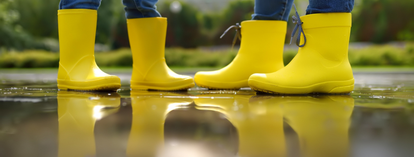 two people facing one another wearing yellow rain boots