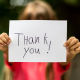 Girl holding a sign that reads "thank you"