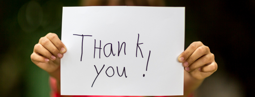 Girl holding a sign that reads "thank you"